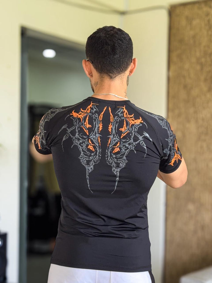 Polera Gym Breathe Divinity de compresion negro con naranja